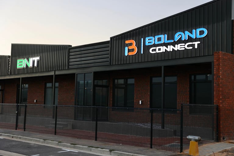 Exterior of Bold Connect business building with blue and orange signage, brick facade, dark windows, and metal railings